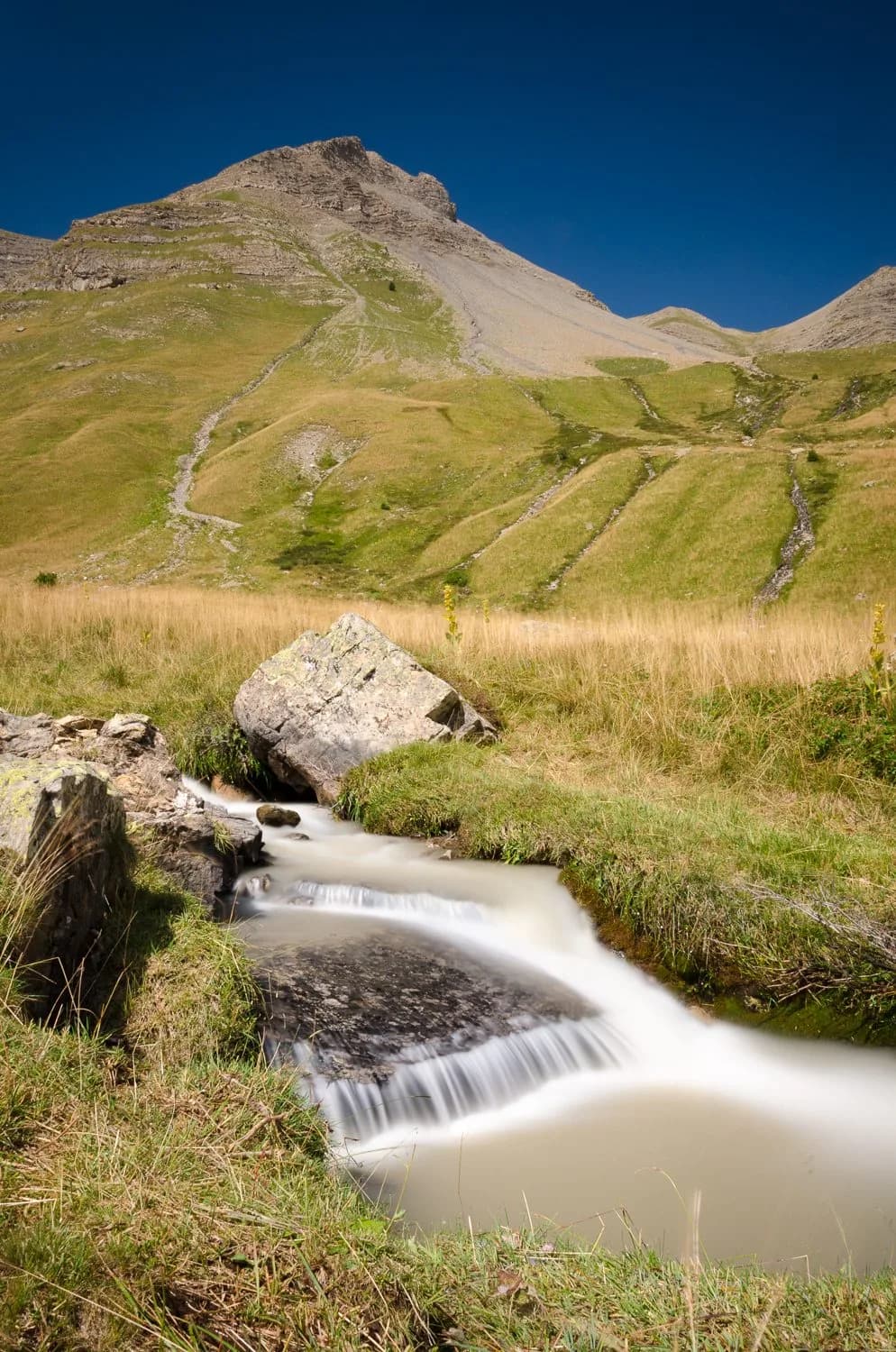 Cascade de montagne, l'eau filée en voile soyeux par une pose longue