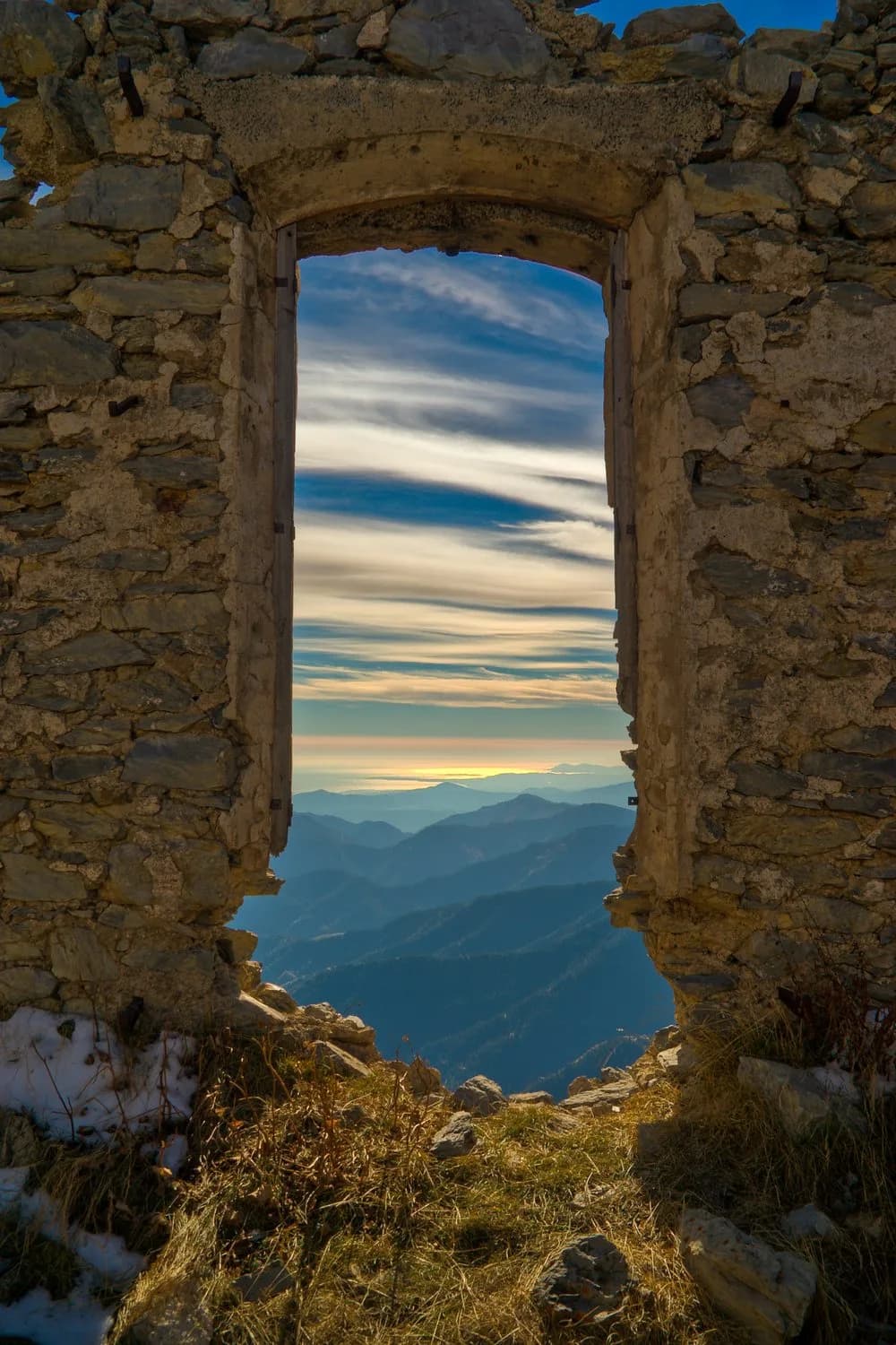 Porte en ruine cadrant un paysage de montagne