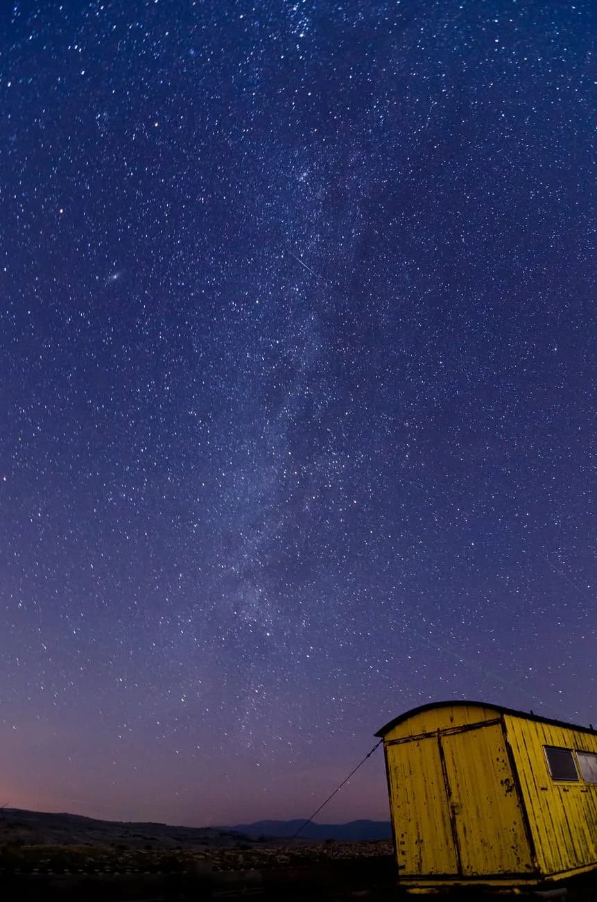 Voie lactée au dessus d'une vieille roulotte, paysage de nuit sur le plateau de Calern